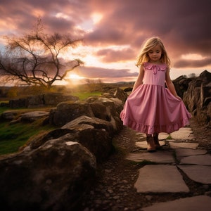 Könnte beinhalten: Ein junges Mädchen in einem rosa Kleid geht auf einem Steinweg. Der Weg ist von großen Felsen und grünem Gras umgeben. Der Himmel ist in leuchtenden Rosa- und Orangetönen mit Wolken. Die Sonne geht in der Ferne unter.