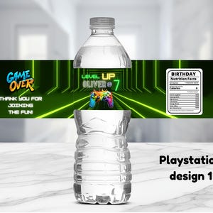 May include: A water bottle with a custom label featuring a gaming theme. The label has the words "GAME OVER" and "LEVEL UP OLIVER 7". It also includes a nutrition facts label and the text "Playstation design 1".