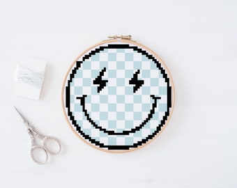May include: A blue and white checkered smiley face with lightning bolt eyes, embroidered on a round hoop.