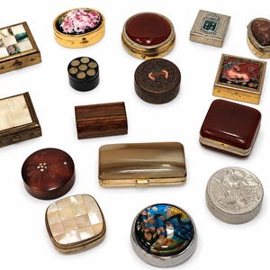 Puede incluir: Una colección de quince pequeñas cajas decorativas y pastilleros de diversas formas, incluyendo diseños cuadrados, redondos, rectangulares y en forma de corazón. Los artículos presentan diversos materiales como nácar, madera, metal y esmalte.