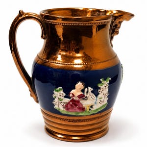 May include: A ceramic jug featuring a metallic copper-coloured finish on the top and bottom sections, with a deep blue central band. The blue section displays a raised, hand-painted relief of a figure in a red dress sitting near white trees.