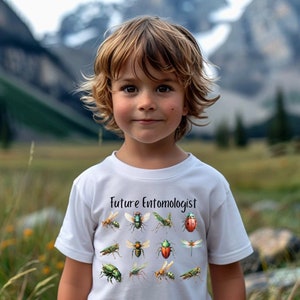 May include: A young person wearing a white t-shirt with the text "Future Entomologist" and a variety of colorful insect illustrations.