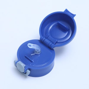 May include: A blue plastic water bottle lid with a clear plastic straw and a gray latch. The lid is open, revealing the interior. The lid is designed to be attached to a water bottle.