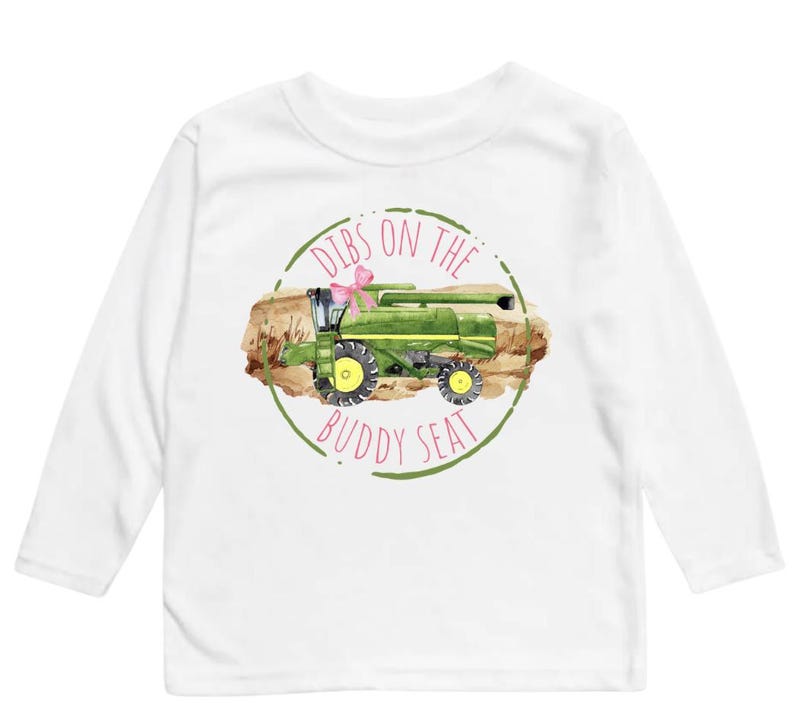 K&ouml;nnte beinhalten: Wei&szlig;es Langarmshirt mit einer Aquarellillustration eines gr&uuml;nen M&auml;hdreschers und einer rosa Schleife. Der Text "Dibs on the Buddy Seat" ist in einem gr&uuml;nen Kreis aufgedruckt.