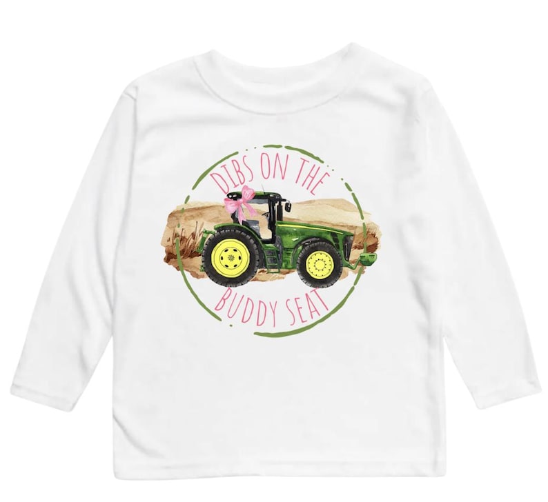 K&ouml;nnte beinhalten: Wei&szlig;es Langarmshirt mit einem gr&uuml;nen Traktor-Motiv und dem Text "Dibs on the Buddy Seat" in einem Kreis. Der Traktor hat gelbe R&auml;der und eine rosa Schleife.