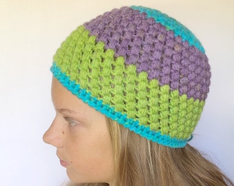 May include: A crocheted hat with a green, purple, and blue color scheme. The hat is made with a textured stitch and has a turquoise trim.