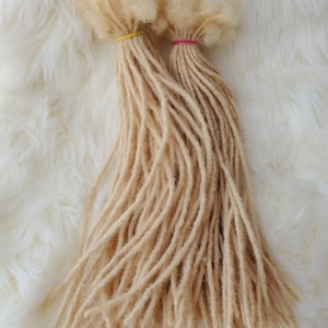Peut inclure: Deux paquets de dreadlocks en cheveux humains blonds clairs. Les dreadlocks sont attachées ensemble avec des élastiques.
