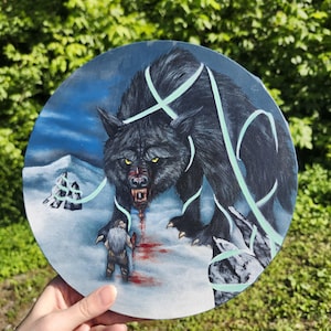 May include: A circular canvas painting depicting a large black wolf with glowing yellow eyes and blood on its muzzle standing over a small figure in a snowy landscape. Pale green ribbons swirl around the wolf and the snowy terrain.