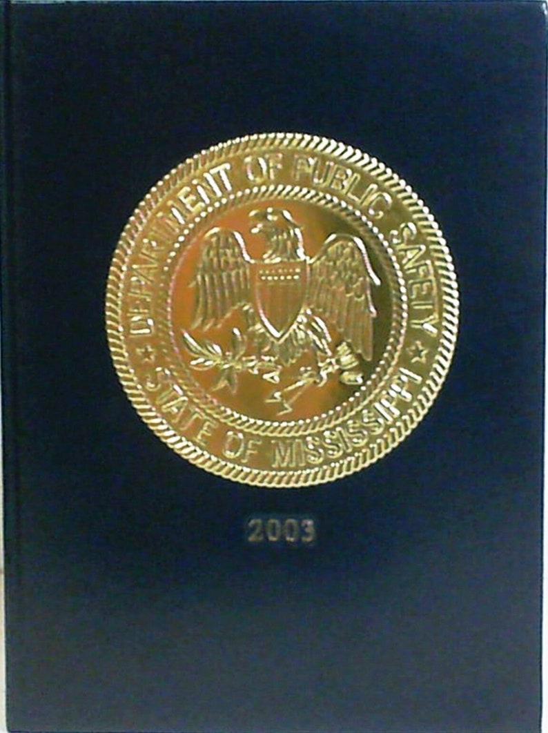 May include: A gold seal with the words 'Department of Public Safety State of Mississippi' and a bald eagle with a shield on its chest. The year 2003 is printed below the seal on a dark blue background.