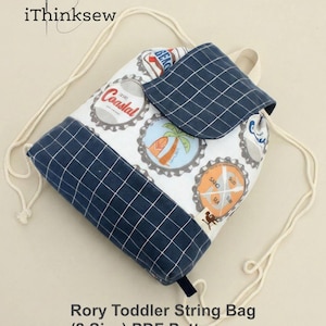 May include: A drawstring backpack with a flap closure, featuring a white fabric base adorned with colorful bottle cap designs. The bag has navy blue checkered fabric accents and a cream-colored drawstring. The text "Rory Toddler String Bag (2 Size) PDF Pattern" is visible.