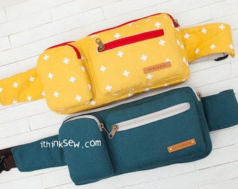 May include: Two fanny packs, one yellow with white crosses and a red zipper, and one teal blue with a white zipper. Both have brown leather tags that say "Handmade".