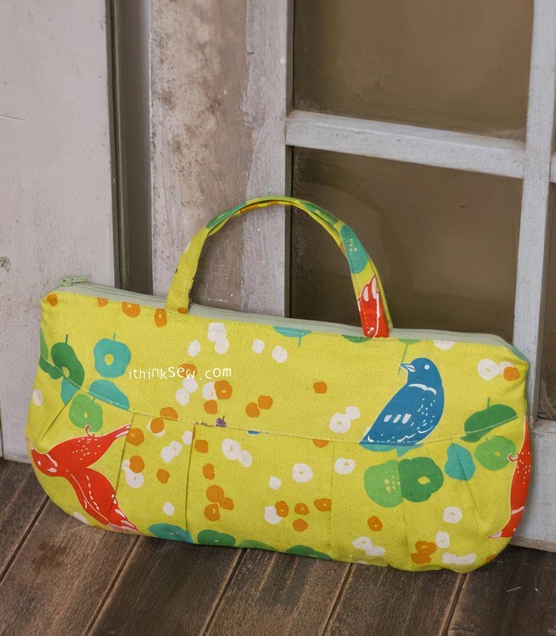 May include: A yellow fabric handbag with a zipper closure and two handles. The bag has a colorful floral and bird print. The text "ithinkSew.com" is printed on the front of the bag.