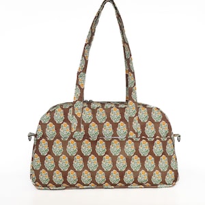 May include: A brown tote bag with a repeating floral pattern in yellow, green, and white. The bag has two handles and a zippered closure. The bag is designed for carrying items.