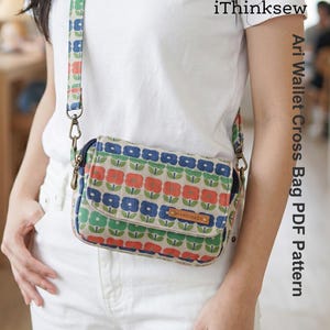 May include: A floral patterned crossbody bag with a matching strap. The bag features a flap closure and a small leather tag that reads "HANDMADE". The bag is decorated with red, blue, and green flowers on a beige background. The text "iThinksew" is visible.