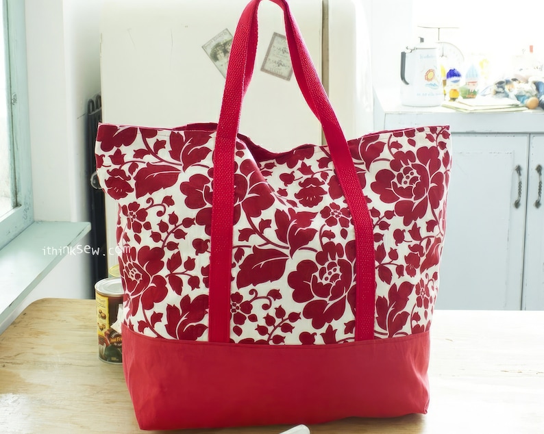 May include: A red and white floral tote bag with red handles. The bag has a solid red bottom.