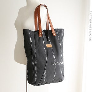 May include: A black canvas tote bag with white polka dots and brown leather handles. The bag has a small label with the text "ithinksew" on the front.