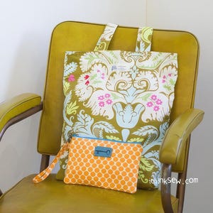 K&ouml;nnte beinhalten: Ein gelber Stuhl mit einer gro&szlig;en Tragetasche mit floralem Muster und einer kleineren orangefarbenen Clutch mit Punkten und einem Schl&uuml;sselanh&auml;nger. Die Tragetasche hat ein blaues und wei&szlig;es Etikett mit der Aufschrift "ithinksew.com".