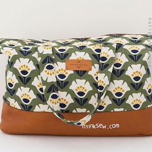 Puede incluir: Una bolsa de mano de tela con estampado floral verde y blanco, ribetes y asas de cuero marrón. La bolsa tiene cierre de cremallera y una etiqueta de cuero que dice "Handmade". La bolsa está hecha por thinkSew.com.