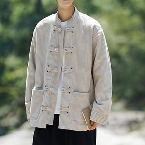 May include: Beige corduroy jacket with a mandarin collar and toggle fastenings. The jacket has two front pockets and long sleeves. The neutral colour and classic design make it a versatile outerwear option.