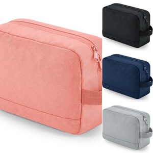 May include: Four toiletry bags in different colours: pink, black, navy blue, and grey. Each bag has a zipper closure and a carrying handle.