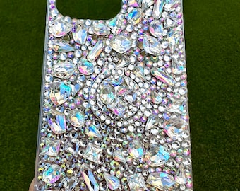 May include: A clear phone case covered in iridescent rhinestones of various shapes and sizes.