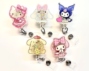 Könnte beinhalten: Fünf farbige Charakter-Ausweishalter mit durchsichtigen Plastikhüllen. Die Charaktere sind Hello Kitty, My Melody, Pompompurin, Kuromi und Cinnamoroll.