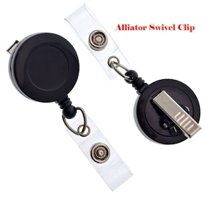 May include: Two black retractable badge reels with alligator swivel clips. One reel has a clear plastic badge holder attached. The other reel has a silver alligator clip.