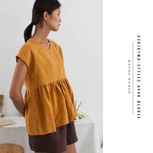 May include: A mustard yellow linen blouse with a ruffled hem and short sleeves. The blouse is worn with brown shorts. #2616TWO - STYLESAVAH BLOUSE MOCHA WOMEN