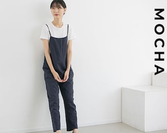 Puede incluir: Una mujer lleva una camiseta blanca y un mono azul oscuro. El mono tiene pierna ancha y está hecho de una tela suave y cómoda. La mujer está de pie sobre un fondo blanco. La palabra "MOCHA" está escrita en letras negras en el lado derecho de la imagen.