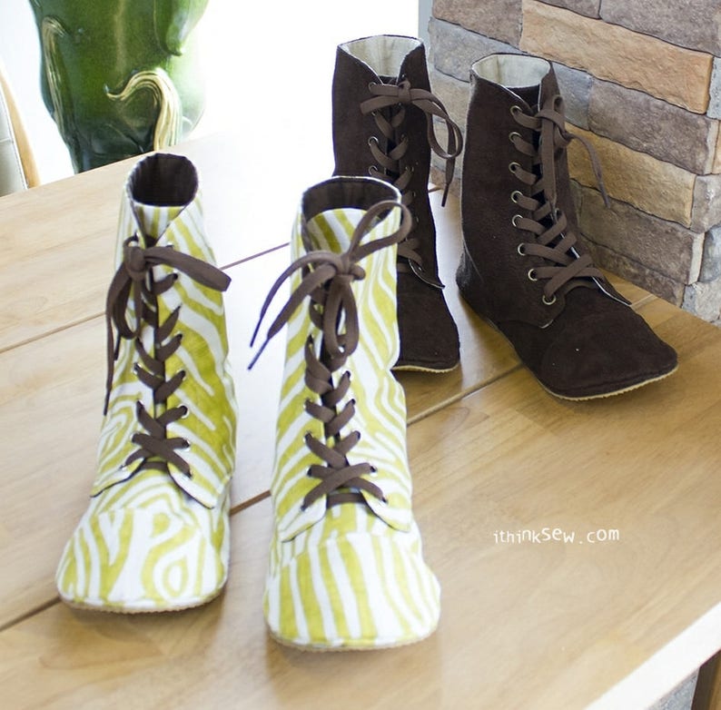May include: Two pairs of ankle-high boots with laces. One pair is brown and the other pair is white with green stripes.