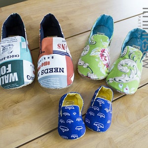 May include: Five pairs of colorful fabric slippers. The slippers are made from different fabrics, including floral, geometric, and patterned fabrics. The slippers are all different sizes, with some being larger than others.