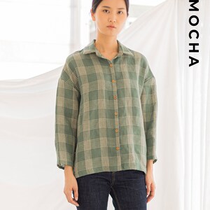 Peut inclure: Une chemise &agrave; carreaux verts et blancs avec un devant boutonn&eacute;. La chemise a une coupe d&eacute;contract&eacute;e et est faite d'un tissu l&eacute;ger.