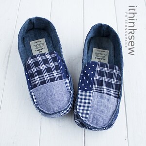 May include: A pair of blue denim slippers with a patchwork design featuring different blue and white patterns, including plaid, gingham, and polka dots. The slippers have a label that reads "Jamaica" on the inside.