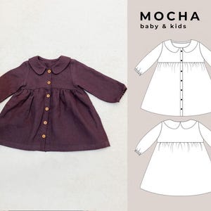 May include: A brown button-up dress with a peter pan collar and long sleeves. The dress has a gathered skirt and is shown on a white background. The dress is also shown in a line drawing on the right side of the image. The text "MOCHA baby & kids" is shown in the top right corner of the image.