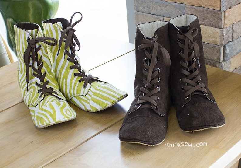 May include: Two pairs of lace-up boots. One pair is brown suede and the other pair is green and white with a zebra print.