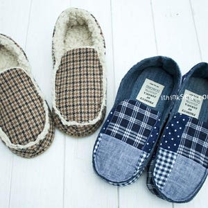 May include: Two pairs of handmade slippers. One pair is brown and white with a houndstooth pattern. The other pair is blue and white with a patchwork design. The slippers are made from recycled materials.