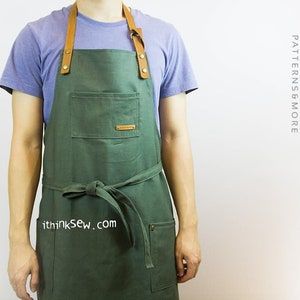 May include: A green canvas apron with brown leather straps and a large pocket. The apron has a brown leather tie and the text "ithinksew.com" is printed on the front.