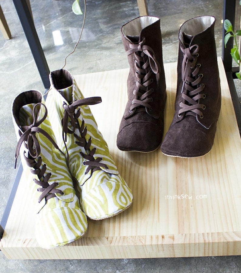 May include: Four pairs of brown and green lace-up boots. Two pairs are brown suede and two pairs are green and white patterned fabric. The boots are on a wooden shelf with the text "ithinksew.com" on the shelf.