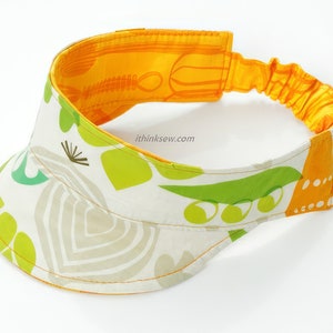 Könnte beinhalten: Ein weißer Visier mit einem gelben Gummiband und einem grün-gelben Blumenmuster. Der Text "ithinkssew.com" ist auf dem Visier aufgedruckt.