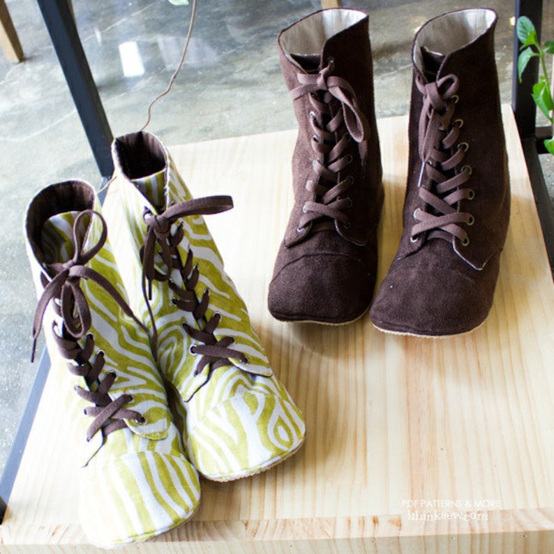 May include: Four pairs of ankle boots. Two pairs are brown suede with lace-up closures. Two pairs are green and white patterned fabric with lace-up closures.