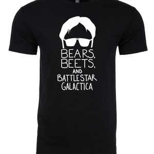 Puede incluir: Camiseta negra con una silueta blanca de un hombre con gafas de sol y el texto "Bears, Beets, and Battlestar Galactica."