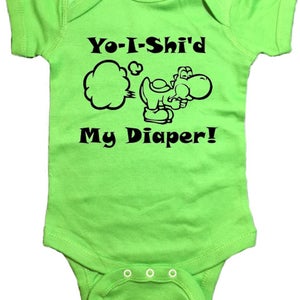 Puede incluir: Un body de bebé verde con un personaje de dibujos animados Yoshi negro y el texto "Yo-I-Shi'd My Diaper!"