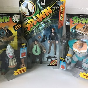 May include: Three unopened action figure packages of Spawn, a comic book character. The figures are Clown, Sam & Twitch, and  Wendigo. Each package features a comic book cover and a special edition sticker.
