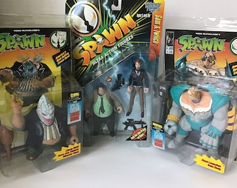 May include: Three unopened action figure packages of Spawn, a comic book character. The figures are Clown, Sam & Twitch, and  Wendigo. Each package features a comic book cover and a special edition sticker.