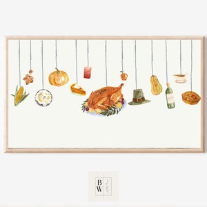 May include: Watercolour illustration of Thanksgiving-themed food and decorations suspended from strings. Includes a roasted turkey, pumpkin, pie, corn, apple, candle, and a pilgrim hat. The artwork is framed in a light wood frame.