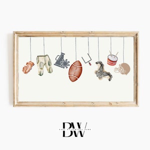 May include: A framed print with a white background and a row of hanging sports-themed illustrations. The illustrations include a football, a helmet, a megaphone, trousers, a shoe, a drum, and a goal post.