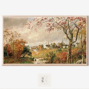 Pode incluir: Pintura de paisagem emoldurada que retrata uma cena de vila no outono. A obra apresenta uma igreja com uma alta torre, rodeada por árvores com folhagem vermelha e amarela. O céu está nublado e um pequeno riacho corre em primeiro plano.
