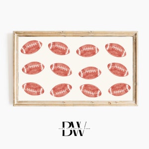 May include: A framed print featuring a pattern of red watercolour footballs on a white background. The frame is a light wood colour.