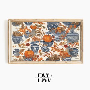May include: A framed print featuring a repeating pattern of blue and white porcelain teacups, bowls, and vases with orange pumpkins and autumn leaves on a white background.
