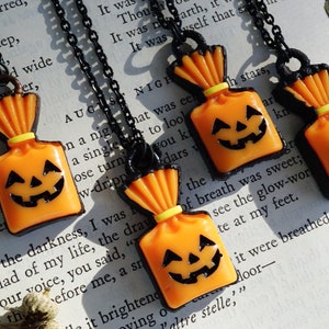 May include: Four orange and black Halloween-themed necklaces with a jack-o'-lantern face on a candy bag charm.